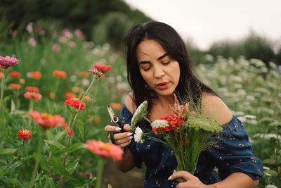 A young woman prune flowers in a floristic flower farm. woman florist.