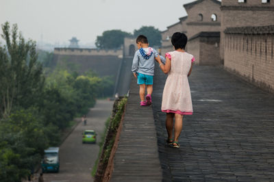 Rear view of women walking on footpath