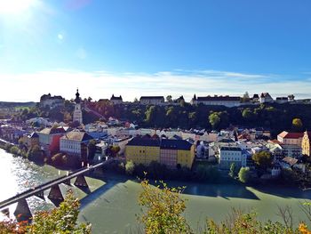 High angle view of river and buildings against blue sky