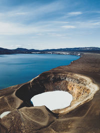 High angle view of volcanic crater by sea