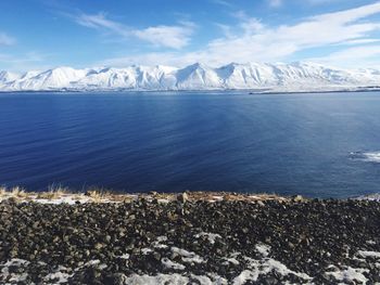 Scenic view of sea and snowcapped mountain against sky