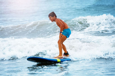 Full length of young man surfing in sea