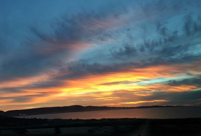 Scenic view of sea against cloudy sky at sunset