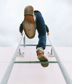 Low angle view of man on staircase against sky