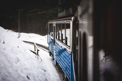 Train moving by snow covered hill