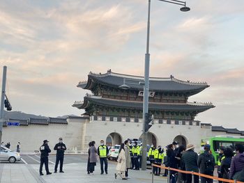 People on building against cloudy sky