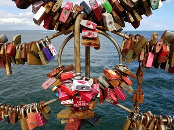 Close-up of padlocks hanging on railing by river