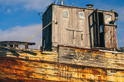 Low angle view of old abandoned boat against sky