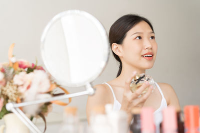 Portrait of a smiling young woman holding camera