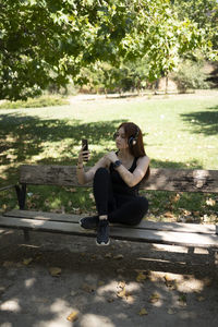 Side view of woman sitting on park