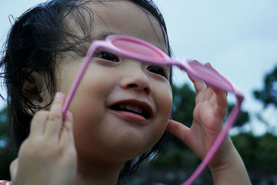 Close-up of cute girl holding sunglasses