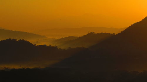 Scenic view of mountains against orange sky during sunset