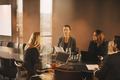 Legal colleagues planning over laptops and documents at conference table in law office