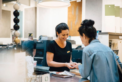 Sales person assisting female customer at hardware store