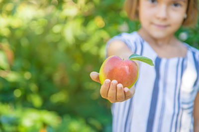 Close-up of young woman holding apple