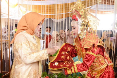 Woman and bride performing rituals during wedding ceremony