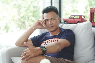 Portrait of young man sitting on sofa