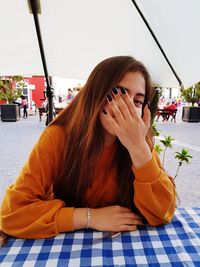 Portrait of young woman sitting outdoors