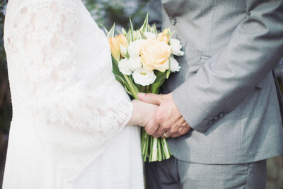 Midsection of man holding flower bouquet