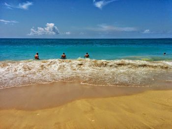 People on beach against blue sky