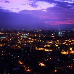 Illuminated cityscape against sky at night