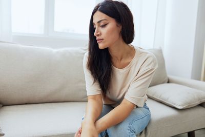 Young woman sitting on sofa at home