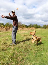 Full length of man playing with dog on land