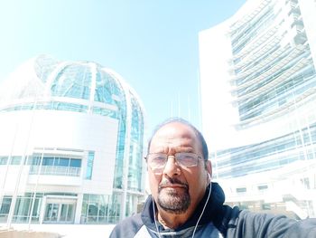 Portrait of man against modern buildings in city