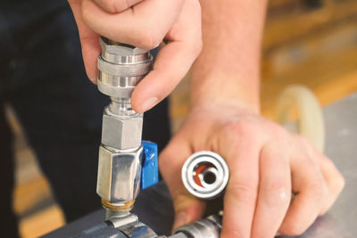 Cropped image of plumber attaching pipe on metal