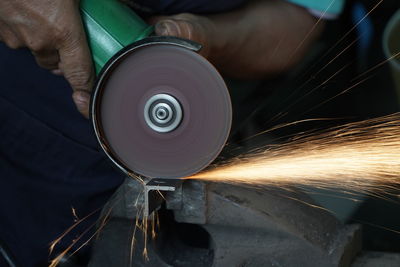 Midsection of man cutting metal