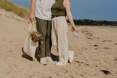 Midsection of man standing at sandy beach