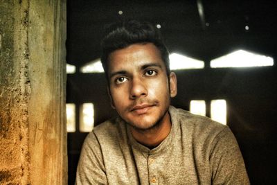 Close-up of thoughtful man sitting at doorway