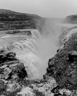 Scenic view of waterfall against sky