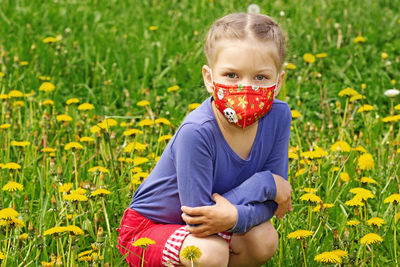 Portrait of young woman sitting on grassy field