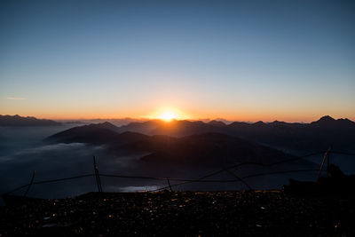 Scenic view of silhouette mountains against sky at sunset