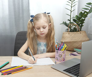 Full length of girl sitting on table