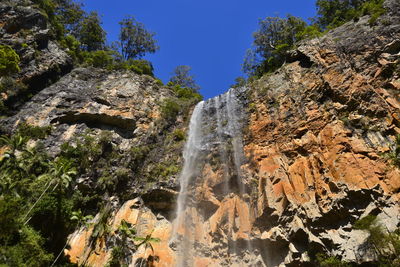 Low angle view of waterfall against sky