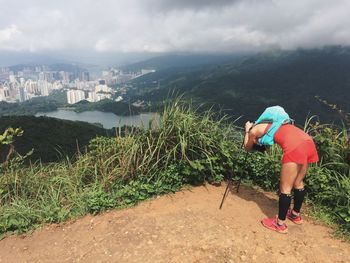 Rear view of boy standing on mountain against sky