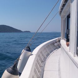 Boat sailing on sea against clear sky