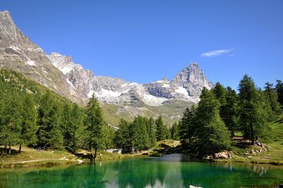 Scenic view of lake and mountains against blue sky