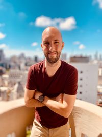 Portrait of man standing against cityscape