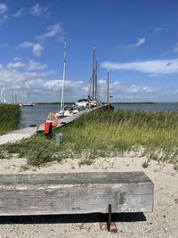 Sailboat on sea shore against sky