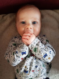 Portrait of cute baby boy on bed at home