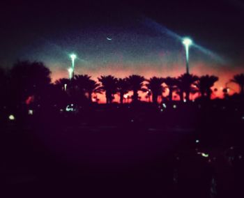 Illuminated street light against sky at night