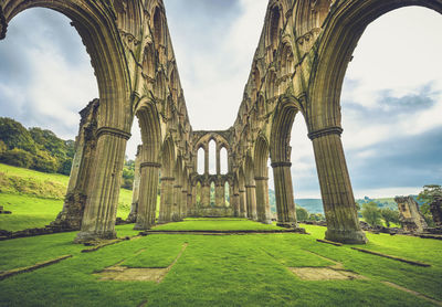 Arched structure on field against sky