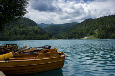 Boat moored by lake against sky
