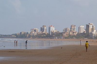 People on beach against clear sky