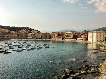 Buildings by sea against sky