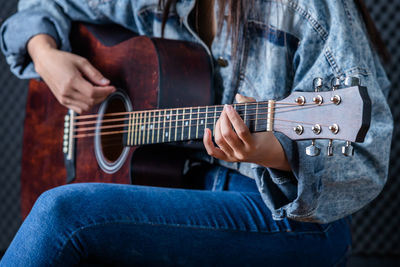 Midsection of man playing guitar