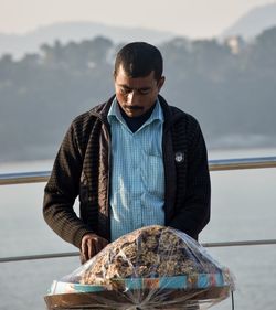 Man holding fish in boat against sea